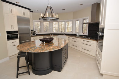 Inspiration for a large contemporary u-shaped eat-in kitchen in Edmonton with a farmhouse sink, shaker cabinets, beige cabinets, granite benchtops, black splashback, glass tile splashback, stainless steel appliances, ceramic floors and with island.