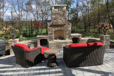 Mid-sized elegant backyard concrete paver patio photo in Other with a fire pit and no cover