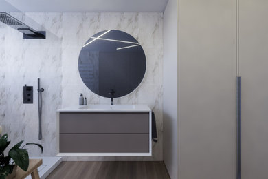 Réalisation d'une salle de bain principale design avec du carrelage en marbre, une douche à l'italienne, un sol en bois brun, un plan vasque, meuble simple vasque et meuble-lavabo encastré.