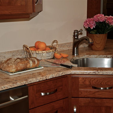 Warm Wood Kitchen Remodel | Angled Granite Island & Integrated Display Cabinets