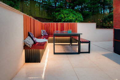Design ideas for a large contemporary sloped partial sun garden for summer in Glasgow with decking and a wood fence.