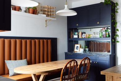 Example of an eclectic medium tone wood floor and brown floor breakfast nook design in DC Metro with white walls