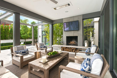 Inspiration for a large contemporary backyard stone patio remodel in Other with a fire pit and a roof extension