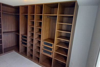 Imagen de armario vestidor unisex moderno de tamaño medio con armarios abiertos, puertas de armario de madera en tonos medios, suelo de baldosas de cerámica y suelo beige