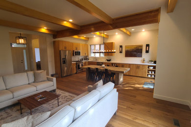 Living room - mid-sized open concept light wood floor living room idea in Salt Lake City with beige walls, a standard fireplace, a stone fireplace and a wall-mounted tv