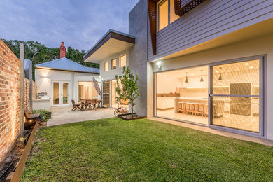 This is an example of a large modern backyard patio in Perth with concrete pavers.
