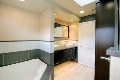 Mid-sized trendy master blue tile and porcelain tile limestone floor bathroom photo in San Francisco with recessed-panel cabinets, dark wood cabinets, a two-piece toilet, blue walls and a vessel sink