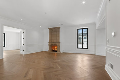 Inspiration for a large modern enclosed light wood floor and beige floor family room remodel in Chicago with white walls, a standard fireplace and a stone fireplace