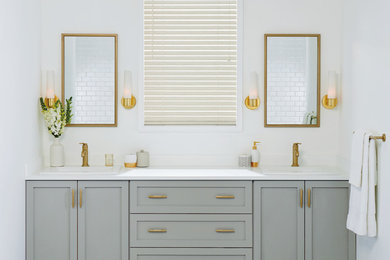 Inspiration for a mid-sized transitional master porcelain tile bathroom remodel in New York with shaker cabinets, gray cabinets, white walls, a drop-in sink and solid surface countertops