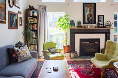 Inspiration for a mid-sized transitional open concept light wood floor and brown floor living room library remodel in Nashville with white walls, a standard fireplace, a tile fireplace and a tv stand
