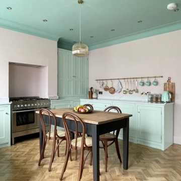 Pastel pink and green hand painted kitchen with fluted glass wall cabinets