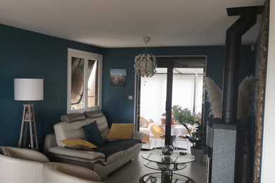 Réalisation d'un salon gris et jaune minimaliste de taille moyenne et ouvert avec un mur bleu, un sol en carrelage de céramique, un poêle à bois et un sol gris.
