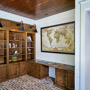 Photo of a country study room in Atlanta with white walls, brick floors and a built-in desk.