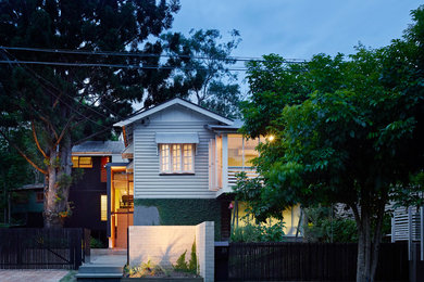 This is an example of a mid-sized traditional split-level grey exterior in Brisbane with wood siding.