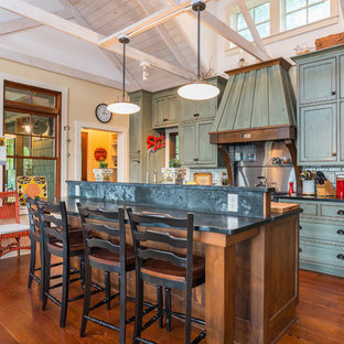 Farmhouse eat-in kitchen ideas - Inspiration for a country galley medium tone wood floor eat-in kitchen remodel in Minneapolis with shaker cabinets, green cabinets, green backsplash, subway tile backsplash, an island and black countertops