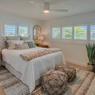 Corner Bedroom With Layered Boho Textiles, Plantation Shutters, and Coastal Acce