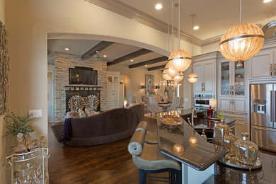 Inspiration for a mid-sized contemporary l-shaped dark wood floor eat-in kitchen remodel in Austin with recessed-panel cabinets, beige cabinets, granite countertops, an island, a farmhouse sink, beige backsplash, ceramic backsplash and stainless steel appliances