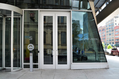 На фото: входная дверь в современном стиле с бетонным полом, двустворчатой входной дверью и стеклянной входной дверью с