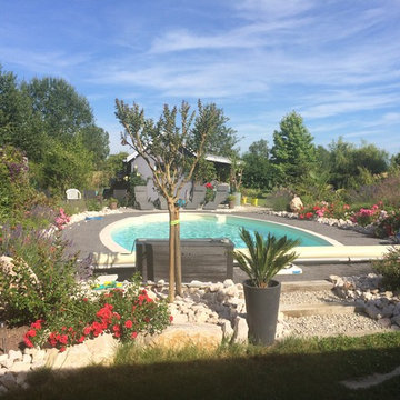 Une piscine au milieu d'un écrin de verdure.