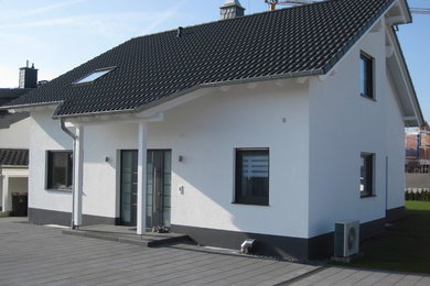 This is an example of a mid-sized traditional one-storey white exterior in Cologne with a gable roof.