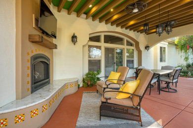Patio - large mediterranean backyard concrete patio idea in Sacramento with a fireplace and a roof extension