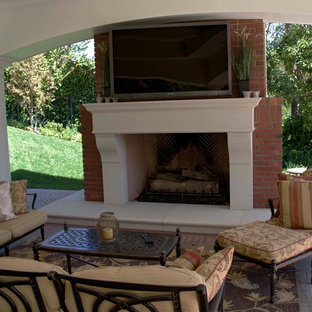 This is an example of a large classic open plan home cinema in Los Angeles with brick flooring and a wall mounted tv.