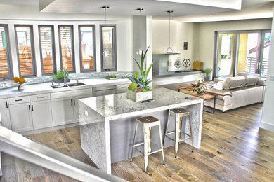 This is an example of a contemporary open plan kitchen in Sacramento with a double-bowl sink, shaker cabinets, white cabinets, grey splashback, stainless steel appliances and with island.
