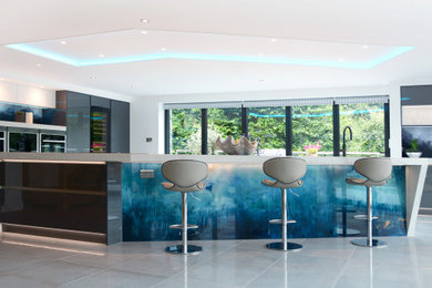 Photo of an expansive contemporary kitchen in Other with blue splashback and glass sheet splashback.