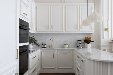 This is an example of a small traditional u-shaped open plan kitchen in London with a submerged sink, raised-panel cabinets, white cabinets, quartz worktops, engineered quartz splashback, integrated appliances, dark hardwood flooring and brown floors.