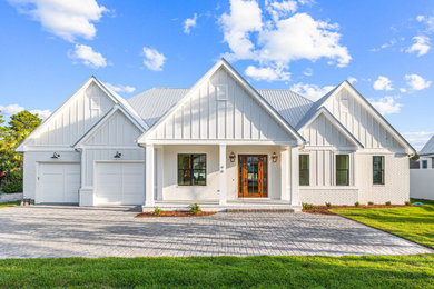 Large coastal white one-story concrete fiberboard and board and batten exterior home idea in Miami with a metal roof and a gray roof