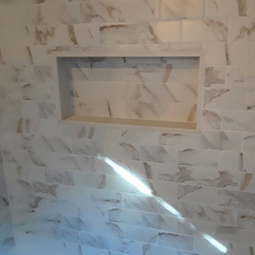 Small scale bathroom. Porcelain tile and shower wall niche.
