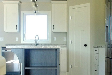 Transitional kitchen photo in Other with shaker cabinets, black cabinets and an island