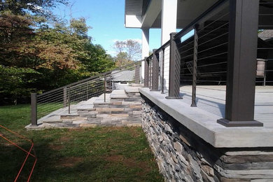 Inspiration for a mid-sized transitional backyard deck remodel in Indianapolis with a roof extension