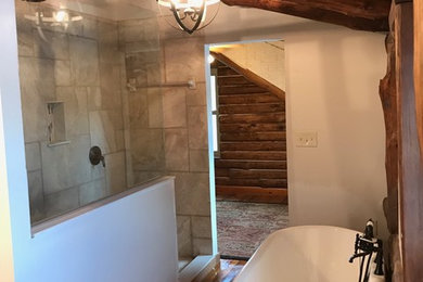 Mittelgroßes Uriges Badezimmer mit freistehender Badewanne, Duschnische, Keramikfliesen, weißer Wandfarbe, braunem Holzboden, braunem Boden, offener Dusche und grauen Fliesen in Tampa