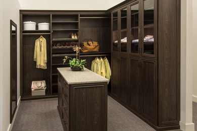 Large traditional gender-neutral walk-in wardrobe in Philadelphia with recessed-panel cabinets, dark wood cabinets and carpet.