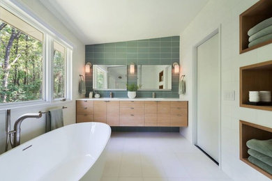 Inspiration for a contemporary 3/4 bathroom in Los Angeles with flat-panel cabinets, light wood cabinets, a freestanding tub, gray tile, porcelain tile, white walls, porcelain floors, an undermount sink, solid surface benchtops and white floor.
