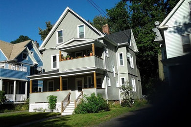 Inspiration for a mid-sized beige two-story mixed siding gable roof remodel in New York