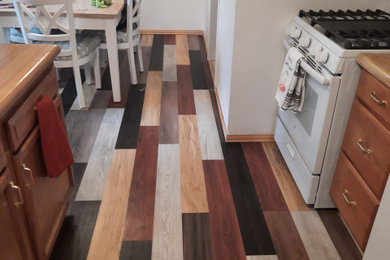 Example of a large laminate floor eat-in kitchen design in Chicago with an island