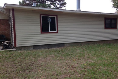 Example of a large classic beige one-story vinyl exterior home design in New Orleans