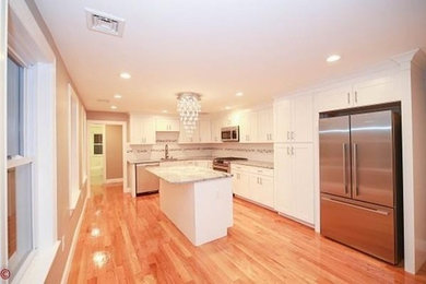 Enclosed kitchen - mid-sized transitional l-shaped enclosed kitchen idea in Boston with shaker cabinets, yellow cabinets, granite countertops and an island