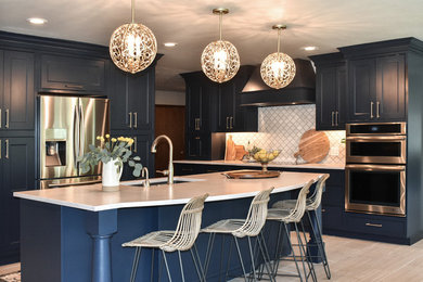 Large transitional l-shaped porcelain tile and beige floor eat-in kitchen photo in Seattle with an undermount sink, beaded inset cabinets, blue cabinets, quartz countertops, white backsplash, marble backsplash, stainless steel appliances, an island and white countertops