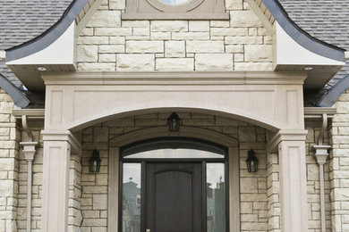 Large elegant beige one-story stone gable roof photo in Toronto