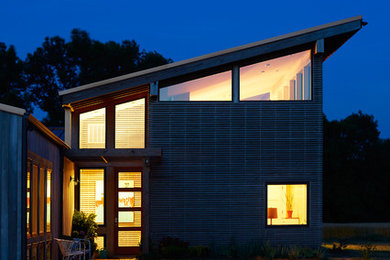 This is an example of a modern one-storey grey exterior in Raleigh with wood siding.