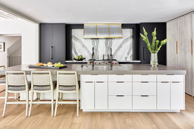 Example of a large transitional vinyl floor and beige floor eat-in kitchen design in Atlanta with a single-bowl sink, flat-panel cabinets, black cabinets, quartz countertops, white backsplash, marble backsplash, an island and gray countertops