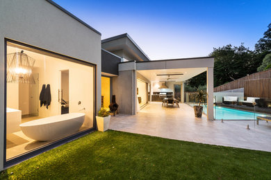 Inspiration for a mid-sized contemporary backyard rectangular pool in Melbourne with a pool house and tile.