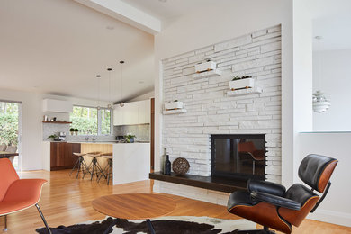 Large trendy formal and open concept laminate floor and beige floor living room photo in Toronto with white walls, a standard fireplace, no tv and a stone fireplace