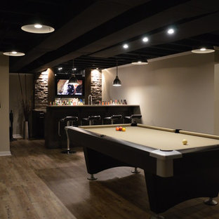 デトロイトの大きいモダンスタイルのおしゃれな地下室 (全地下、ベージュの壁、クッションフロア、暖炉なし、茶色い床) の写真