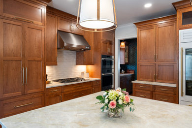 Open concept kitchen - large traditional l-shaped medium tone wood floor open concept kitchen idea in Other with an undermount sink, recessed-panel cabinets, medium tone wood cabinets, quartzite countertops, white backsplash, subway tile backsplash, stainless steel appliances, an island and beige countertops