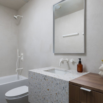Bathroom with terrazzo waterfall vanity, and soaking tub - Fold House