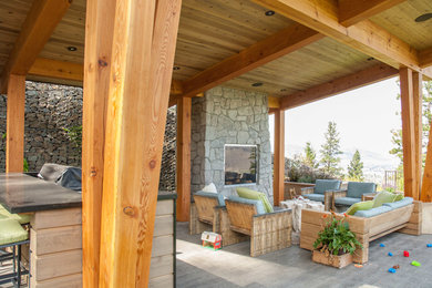 Inspiration for a large contemporary back porch remodel in Vancouver with a fire pit and a roof extension
